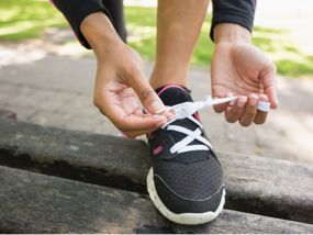 Frau schnürt ihren Laufschuh in Nahaufnahme