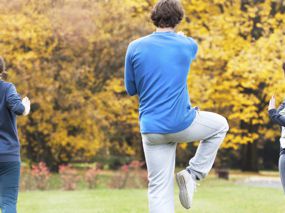 Drei Personen machen Tai Chi im Park