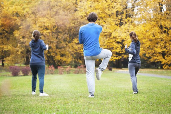 Drei Personen machen Tai Chi im Park