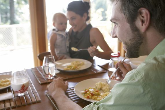 Familie mit Baby beim Essen.