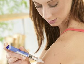Eine Frau verabreicht sich Insulin.