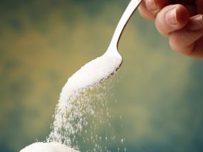 Zucker rieselt von einem Löffel