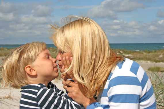 Sohn gibt seiner Mutter einen Kuss. Wind. Ostseestrand.