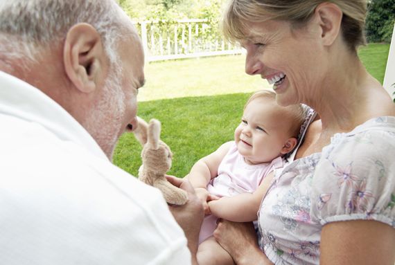 Großeltern halten Baby auf den Arm