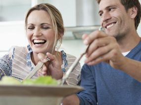 Frau und Mann in ausgelassener Stimmung essen Salat