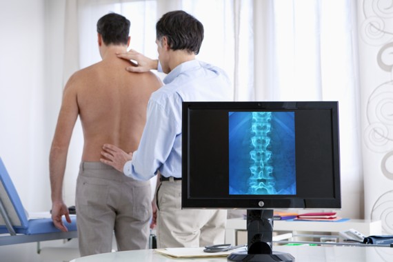 Arzt untesucht den Rücken seines Patienten