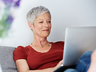 Frau mit Laptop auf der Couch
