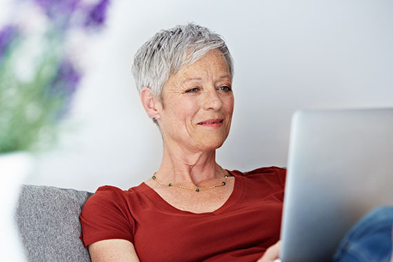 Frau mit Laptop auf der Couch
